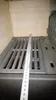 A close-up view of a metal grate with a ruler placed on top, showing measurements. Produktbild-Vorschau
