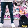 A person is holding a smartphone connected by a cable to a backpack, with graffiti in the background. Produktbild-Vorschau