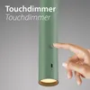 A hand is shown touching a button on a green cylindrical lamp, with text overlay indicating 'Touchdimmer'. Anteprima dell’immagine prodotto