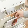 A hand is shown organizing books and notebooks in a beige organizer. Produktbild-Vorschau