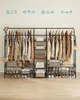A clothing rack filled with clothes, shoes, and storage boxes against a light beige wall. Produktbild-Vorschau