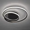 A modern ceiling light fixture with two intertwined rings, one larger than the other, both illuminated with white LED lights. The fixture has a central black circular base. Voir les images du produit