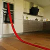 Rote Hot-Wheels-Strecke mit zwei Spielzeugautos, die von einer Küchenmikrowelle bis zu einem Holzboden verläuft Anteprima dell’immagine prodotto