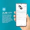 A hand holding a smartphone displaying the JLab app, with text describing the app's features on the left. Produktbild-Vorschau