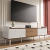 A modern TV stand with a large television mounted above it, in a well-lit room. Náhled obrázku produktu