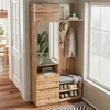 A compact wardrobe with a mirror, bench, and shoe storage in a hallway next to a window. Voir les images du produit