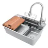 A stainless steel kitchen sink with a faucet and a wooden cutting board. Podgląd zdjęcia produktu