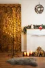 A lit-up decorative tree with warm white lights stands next to a fireplace decorated for Christmas. Voir les images du produit
