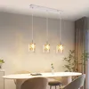 A modern dining room with a table and chairs, illuminated by a linear pendant light fixture. Produktbild-Vorschau