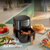 A Philips Airfryer is shown on a kitchen counter with various foods, including chicken, stuffed peppers, and a cake. Produktbild-Vorschau