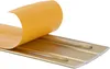 A close-up, angled view of a gold-colored transition profile with its adhesive backing being peeled away. Anteprima dell’immagine prodotto