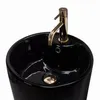 A black ceramic basin with a gold faucet. Produktbild-Vorschau