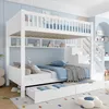 A white bunk bed with storage drawers and shelves, set in a child's bedroom with blue walls and a colorful rug. Produktbild-Vorschau