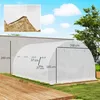 A white greenhouse in an outdoor setting with a wooden deck and grass. Voir les images du produit