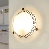 A round ceiling light with a Greek key pattern is mounted on a white wall in a kitchen. Produktbild-Vorschau