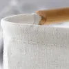 Close-up of the top edge of a fabric laundry basket with a wooden handle. Náhľad obrázku produktu