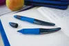 Two blue STABILO pens are placed on an open notebook next to an apple and a blue pencil case. Anteprima dell’immagine prodotto