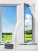 A portable air conditioner hose is sealed into an open window using a fabric seal, with a scenic outdoor view visible through the window. Náhľad obrázku produktu