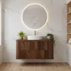 A modern bathroom vanity with a round mirror above it, set against a marble-tiled wall. Náhled obrázku produktu