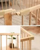 Close-up shots of a wooden baby playpen, showing its construction and connection points. Voir les images du produit