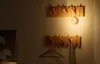 A night light is attached to a wooden coat rack on a wall, with a clothes hanger and a towel also hanging on the rack. Podgląd zdjęcia produktu