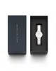 A Daniel Wellington watch is presented in its packaging, with the watch case open and the watch inside. Voir les images du produit