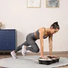 A woman is exercising on a vibration plate in a room. Náhľad obrázku produktu