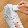 A person is cleaning a dirty white sneaker with a white magic eraser sponge. Produktbild-Vorschau