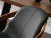 Close-up of a black upholstered chair with wooden accents, next to a wooden table. Voir les images du produit