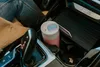 A pink and white Kambukka thermos bottle is placed in a car's cup holder. Náhled obrázku produktu