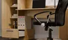 A close-up view of a desk and bookshelf combination, with a black office chair in the foreground. Voir les images du produit