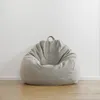A light gray beanbag chair is placed against a white wall on a wooden floor. Voir les images du produit