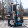 A man is using a wood splitter outdoors. Produktbild-Vorschau