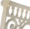 A close-up view of a white cast iron shelf bracket with decorative scrollwork and arched openings. Náhľad obrázku produktu