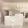 A modern retail store interior with a reception desk and clothing rack. Produktbild-Vorschau