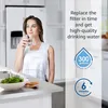 A woman drinks water in a kitchen, with text about water filter replacement. Anteprima dell’immagine prodotto