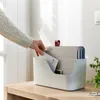 A hand is placing a letter into a document organizer on a wooden desk. Produktbild-Vorschau