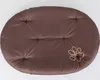 A brown oval dog cushion with a paw print design. Produktbild-Vorschau