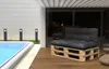 Outdoor patio with a swimming pool and a pallet sofa. Voir les images du produit
