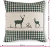 A pillow cover with a green and beige checkered pattern and a central panel featuring two deer silhouettes. Produktbild-Vorschau