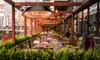 An outdoor patio area with tables and chairs, featuring a hanging heater. Produktbild-Vorschau