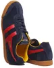 A pair of navy blue Gola Harrier sneakers with red stripes and yellow accents, shown from a slightly angled perspective against a white background. Náhled obrázku produktu