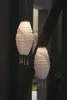 Two white paper lanterns with tassels hang from a wooden beam. Produktbild-Vorschau