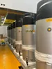 A row of identical water heaters are lined up in what appears to be a warehouse or factory setting. Produktbild-Vorschau