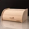 A wooden bread box with a roll-top lid is shown against a dark background. Produktbild-Vorschau