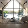 A modern living room with a large window overlooking a snowy forest. Produktbild-Vorschau