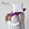 A woman is holding a stack of pillows. Produktbild-Vorschau