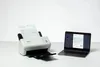 A Brother document scanner is shown next to a laptop, with a document in the scanner and on the laptop screen. Voir les images du produit
