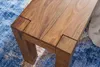 A close-up view of the corner of a wooden bench, showing the joinery and texture of the wood, placed on a patterned rug. Anteprima dell’immagine prodotto