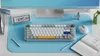 A desk setup with a keyboard, mouse, monitor, and notebook. Produktbild-Vorschau